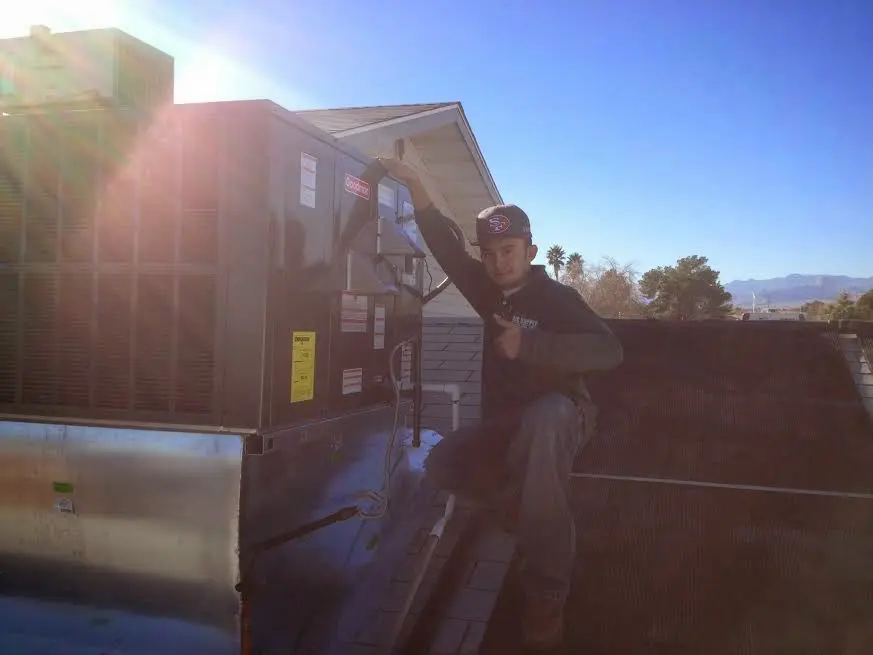 HVAC technician performing HVAC Inspection on a rooftop unit in Marquette